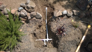 Tapped 3/4" PVC header already in the ground and installed a Tee to bring the water up to the raised bed. 
