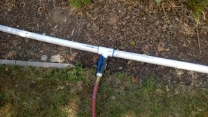 T-fitting with valve to hand watering hose strung across front yard.